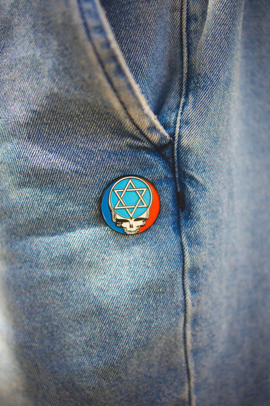 Pin with a Star of David design on a denim jacket