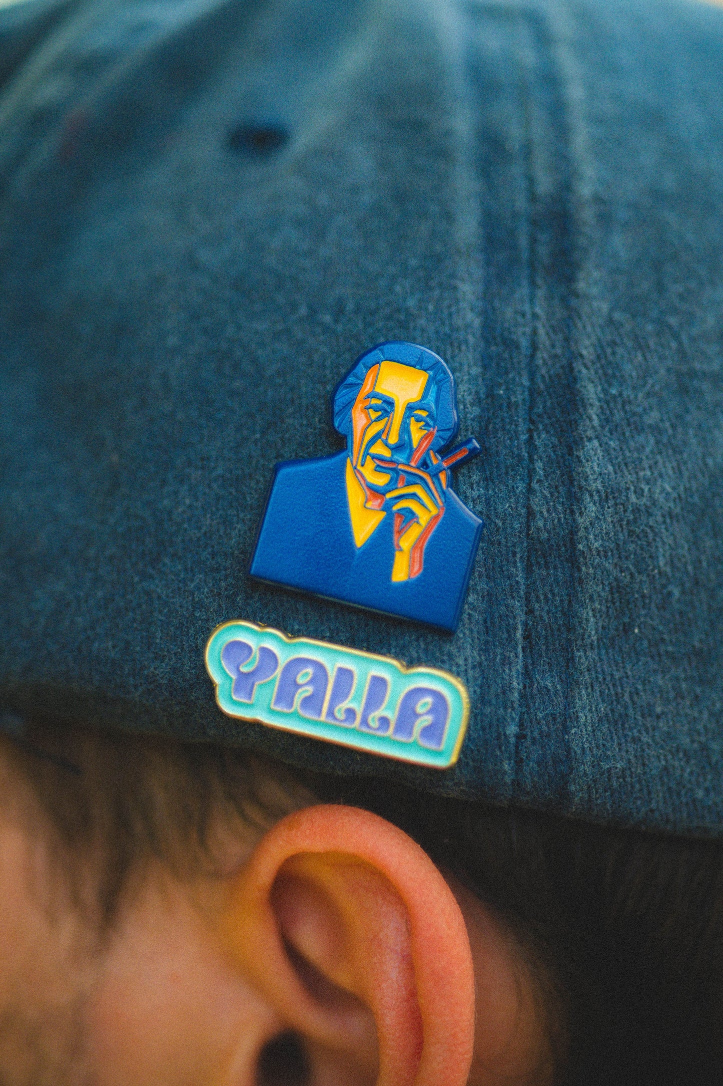 golda and yalla pins on baseball cap