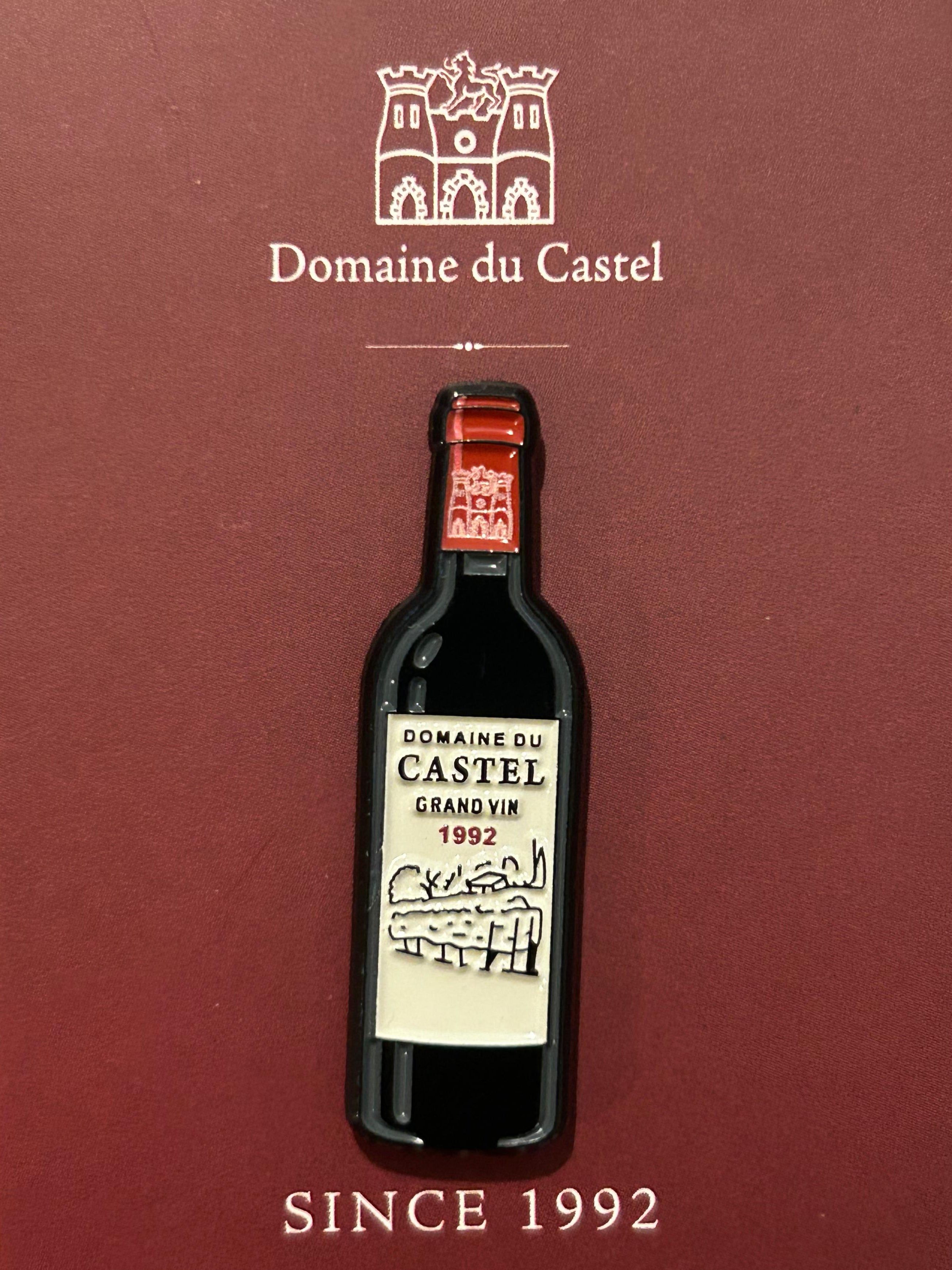 Domaine du Castel wine bottle design on a maroon card
