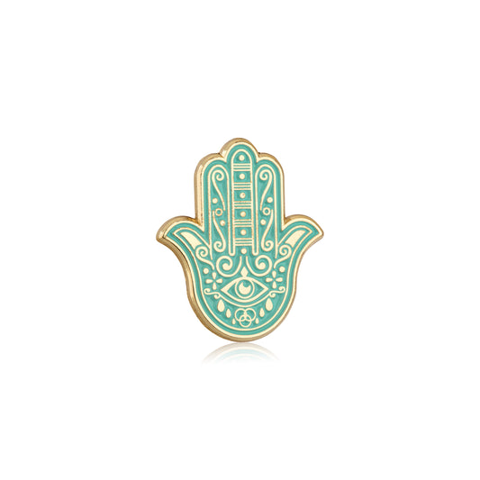 Decorative Hamsa hand pin with turquoise and gold design on a white background