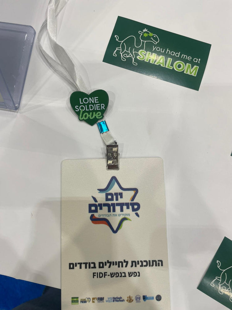 ID badge with star design and text, green heart-shaped tag, and 'Shalom' card on a white background
