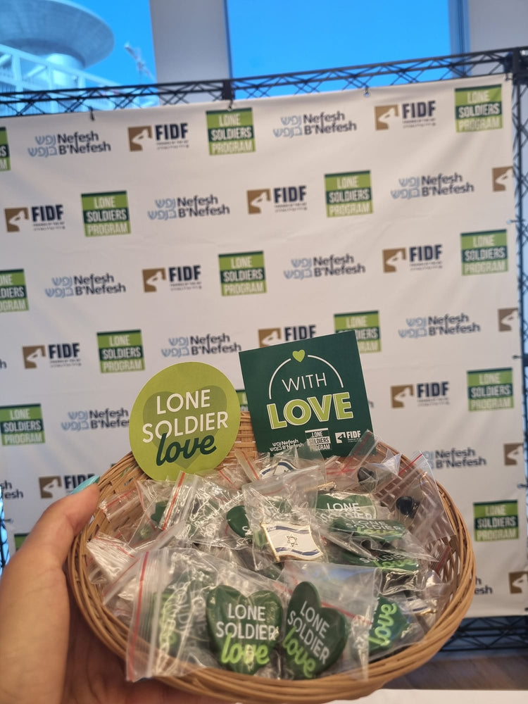 Basket of 'Lone Soldier Love' items with a branded backdrop