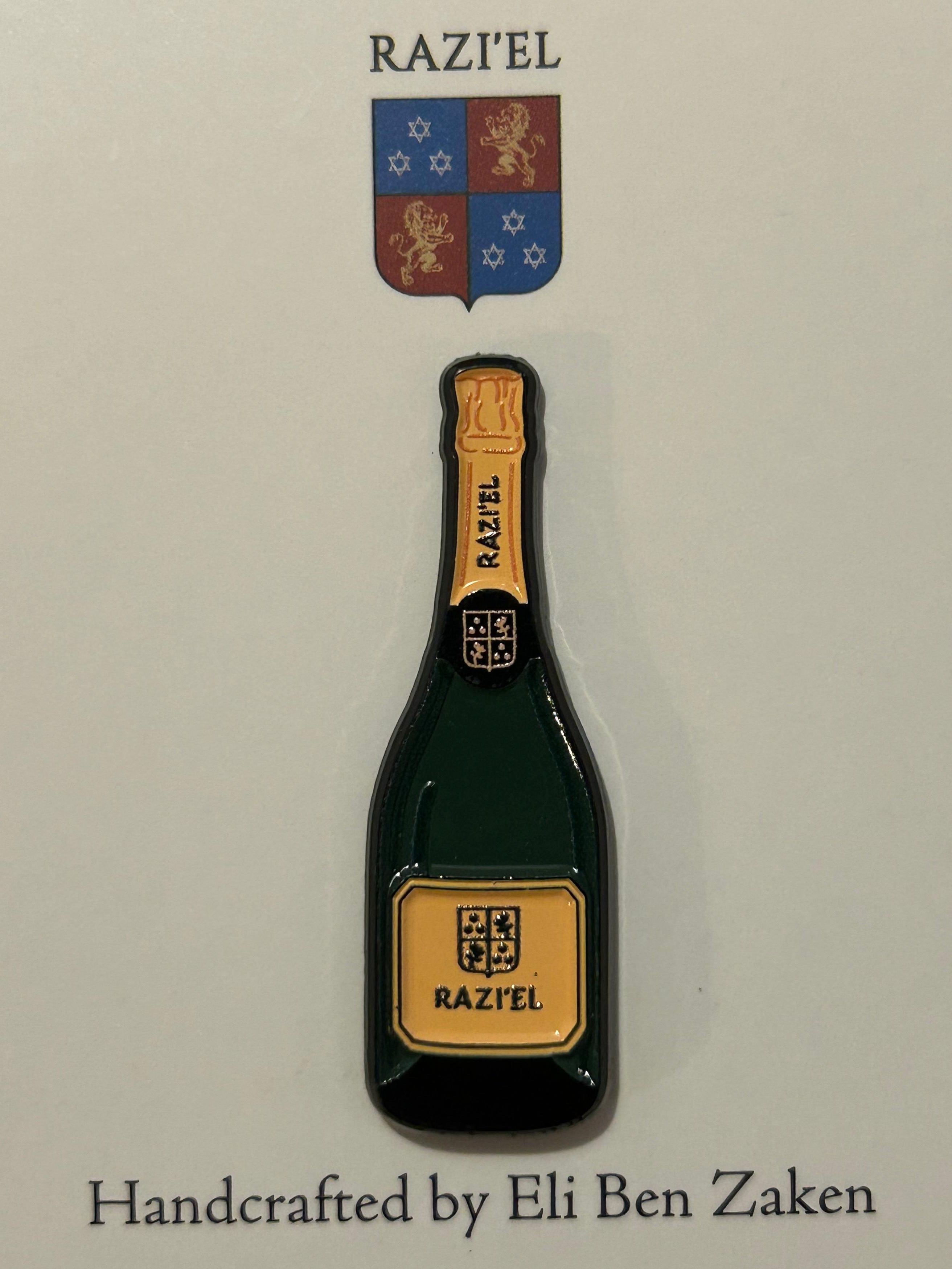 Pin shaped like a bottle with 'RAZI'EL' branding on a white card.