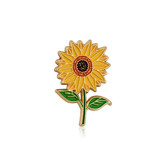 Sunflower-shaped pin with yellow petals and green leaves on a white background
